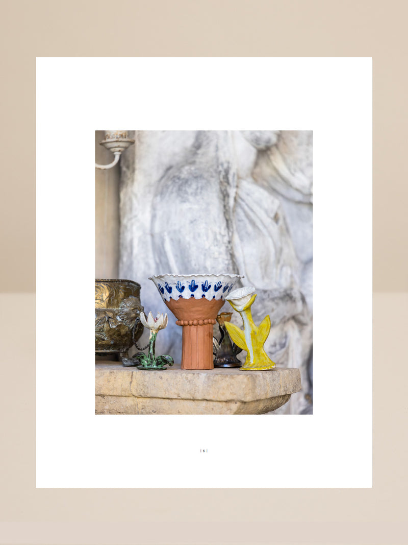 Decorative ceramic vase with blue patterns on a stone ledge with marble background