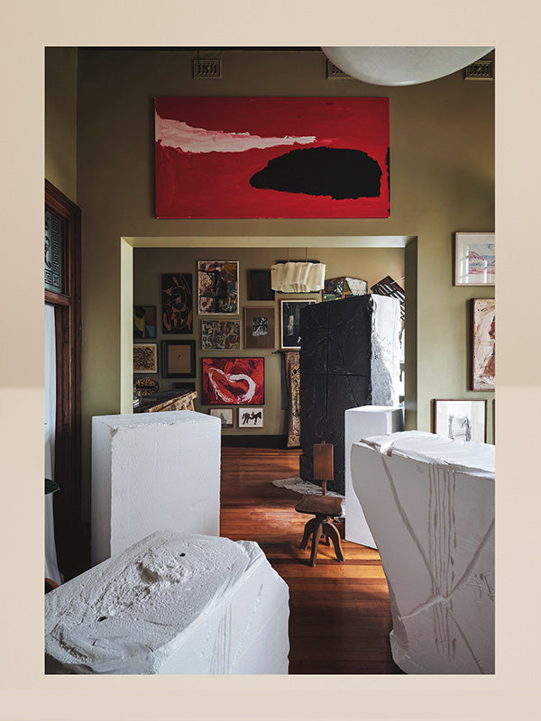 Art gallery with various artworks on the walls and floor.