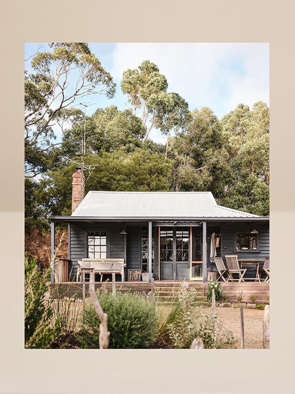 Cottage surrounded by trees with a clear sky