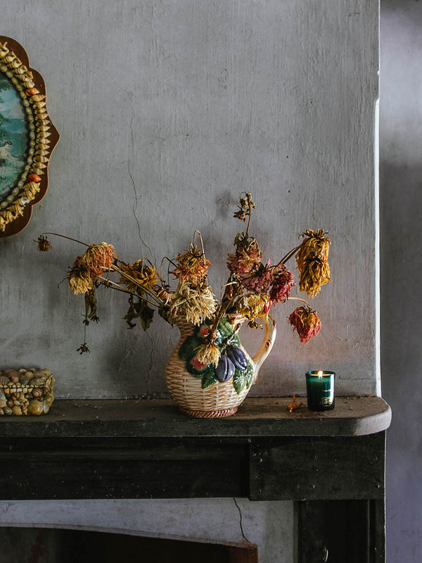 Ocean Isle votive candle glowing on a weathered mantle beneath dried blooms in a vintage jug, bringing coastal light to a quiet corner of an old Australian home.