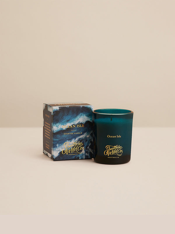 Ocean Isle votive candle and box styled simply against a warm-toned background, showcasing Southern Wild Co’s ocean-inspired design and scent.