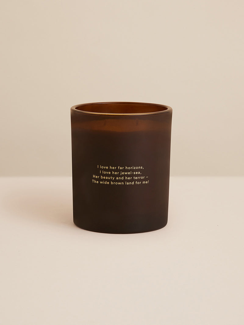 Reverse of Southern Wild Co’s Our Place candle featuring poem inspired by Dorothea Mackellar’s “My Country” – amber glass vessel with gold inscription celebrating the Australian landscape.