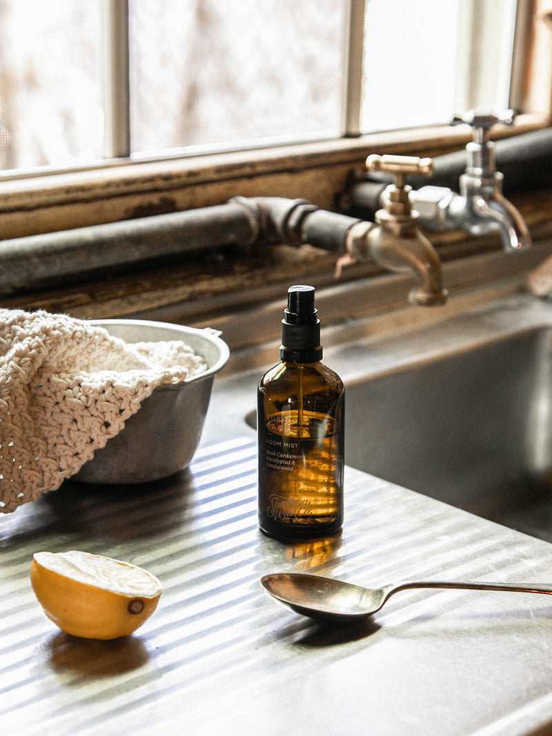 Our Place Room Mist by Southern Wild Co styled beside a vintage sink with lemon, cloth, and metal spoon – handcrafted Australian room spray with bush cardamom, eucalyptus, and sandalwood.