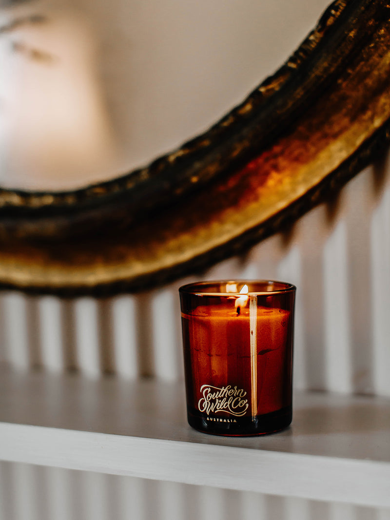 Our Place votive candle by Southern Wild Co beside a running clawfoot bath in a corrugated iron bathroom – artisan soy candle for slow bathing and mindful self-care.