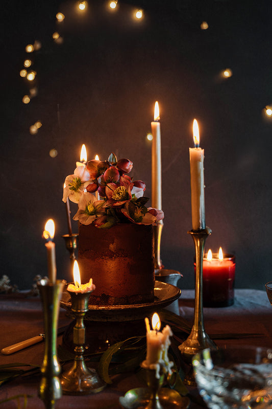 Southern Wild Co birthday cake with candles and flowers on a dark background
