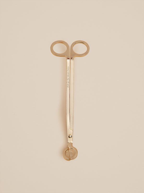 Gold candle wick trimmer engraved with "click go the shears boys", designed by Southern Wild Co for safe and elegant candle care.