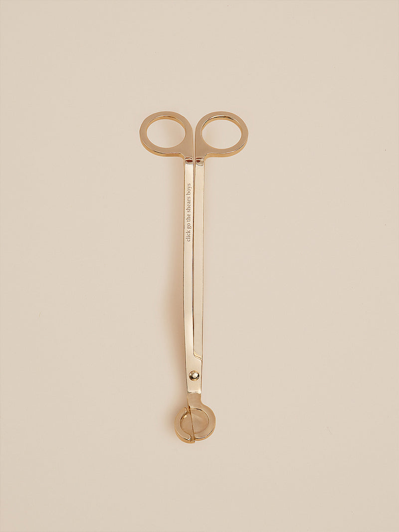 Gold candle wick trimmer engraved with "click go the shears boys", designed by Southern Wild Co for safe and elegant candle care.