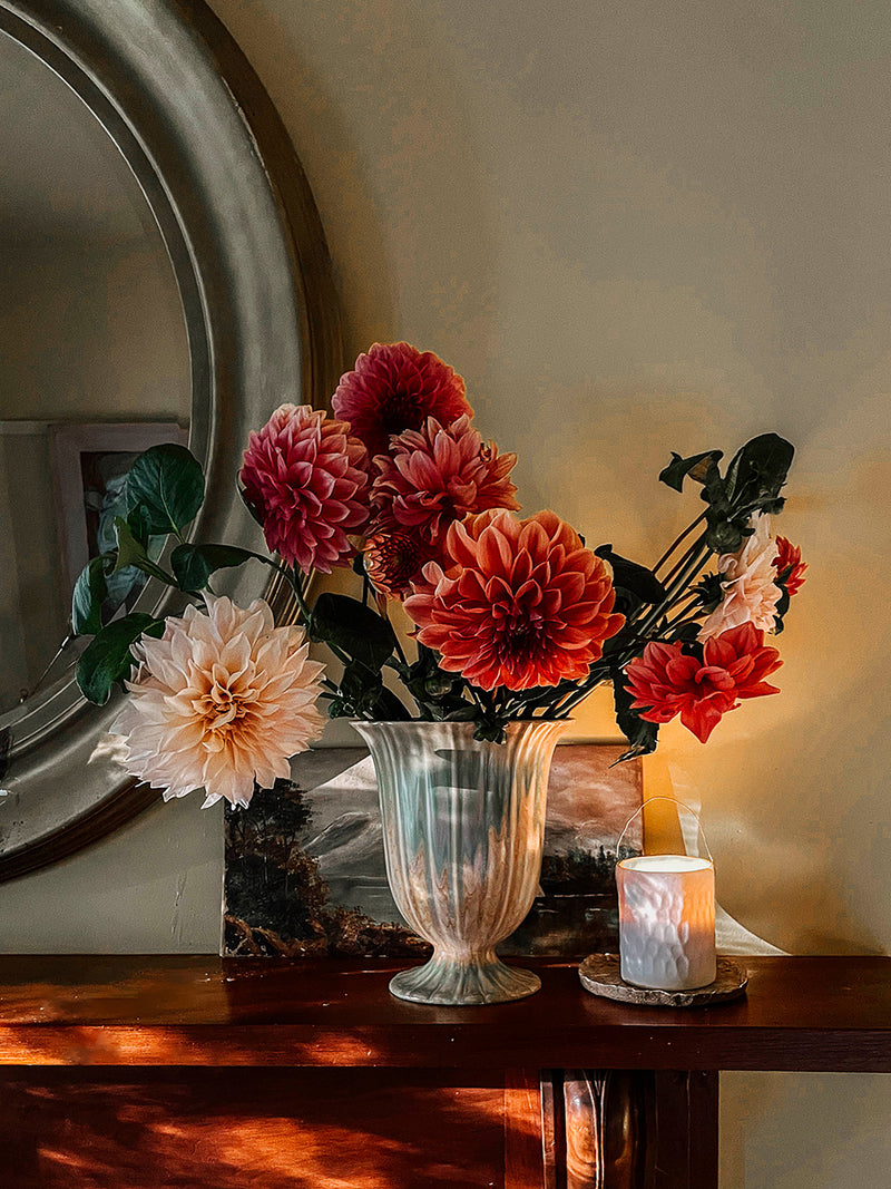 Assorted dahlias in a vintage vase on a wooden mantel with Southern Wild Co candle