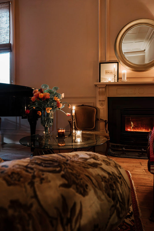 Winter living room with candlelight, fresh seasonal flowers and a glowing fire at Bank House, styled with Southern Wild Co home fragrance for a warm and inviting Australian country home.