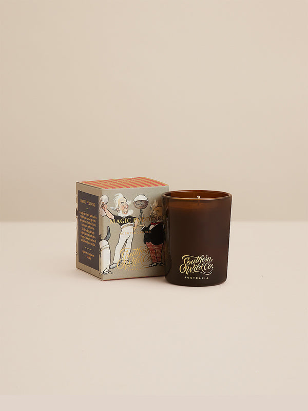 Magic Pudding votive candle beside illustrated round box with bold stripes and classic Australiana artwork — a nostalgic scent inspired by joyful bush tales and sweet citrus spice.