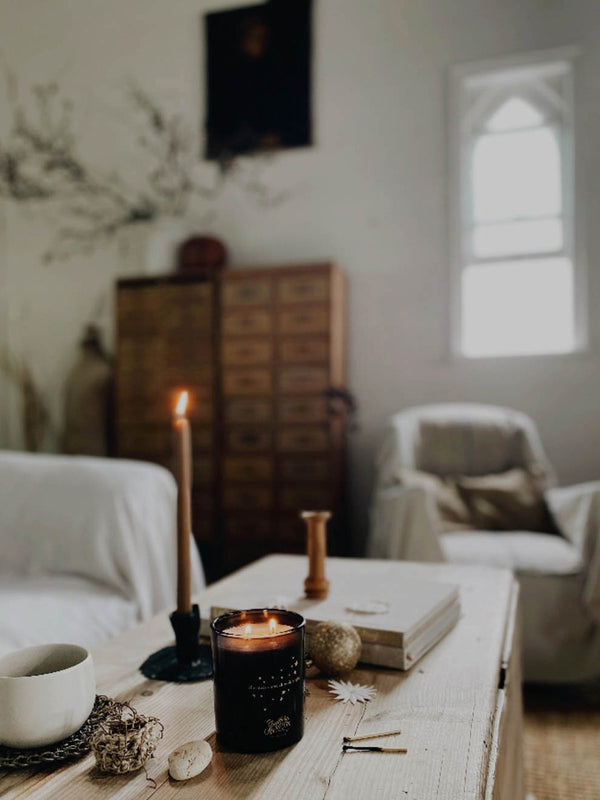 Southern Sky candle alight in a light-filled living space, surrounded by natural textures and objects—inviting calm and connection to the rhythm of the southern seasons.